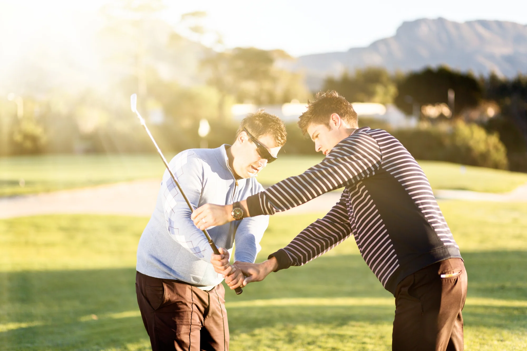 Golfer working on his swing path with an instructor