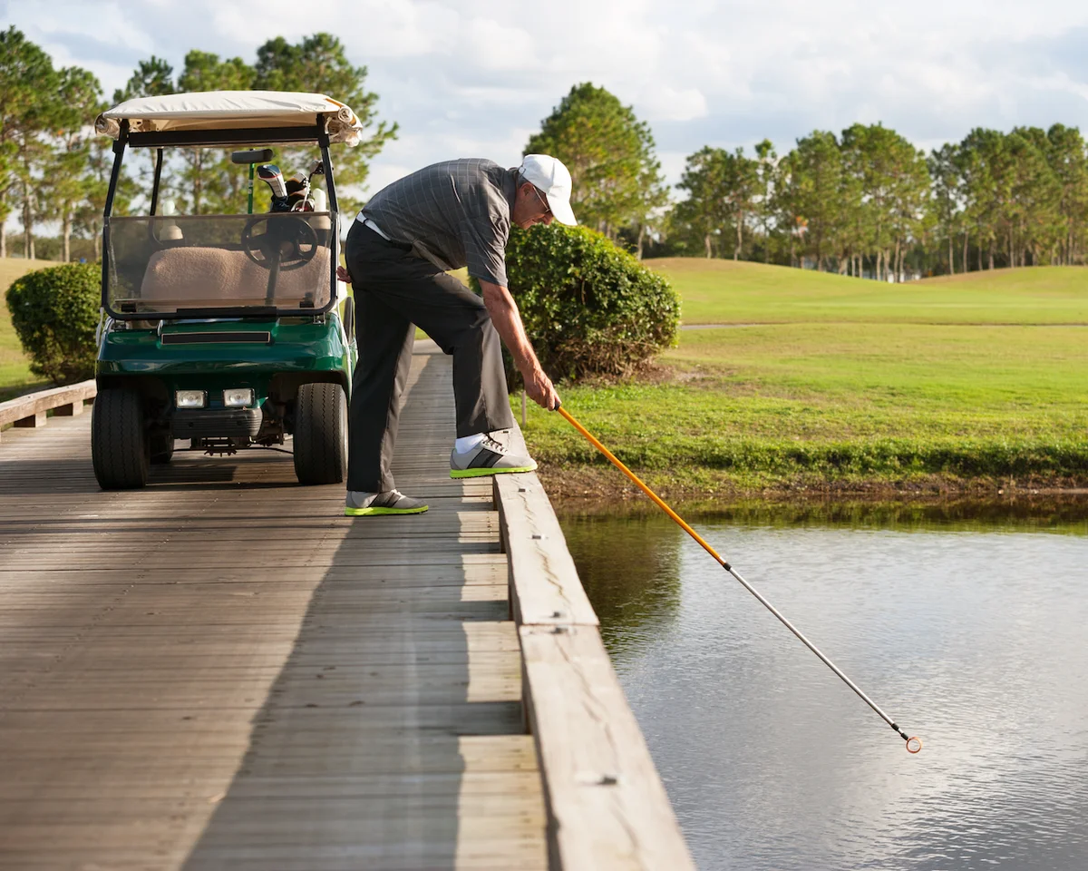 Golfer finding ball in water