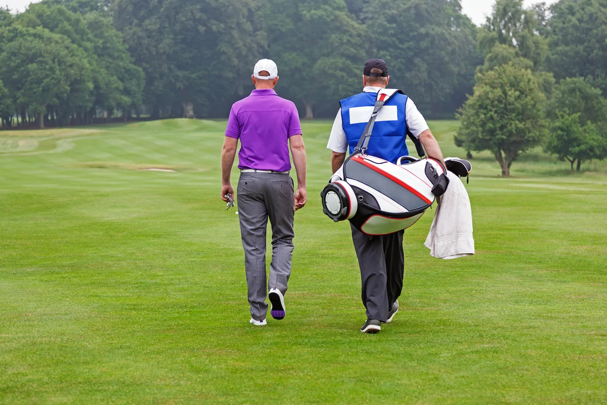 Golfer with caddie on course