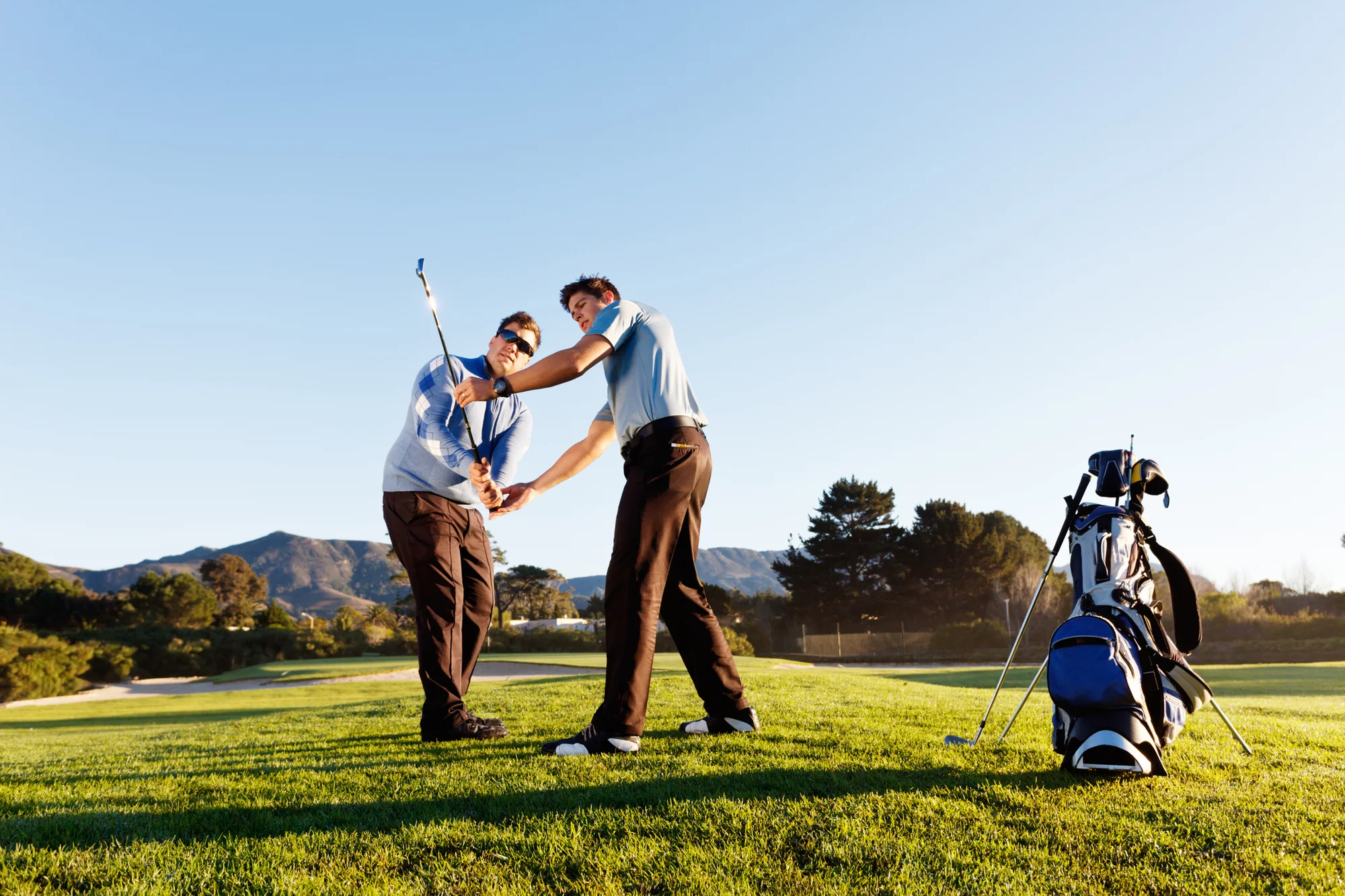 Golf pro and student practicing the golf swing