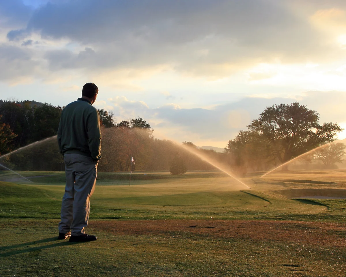 Groundskeeper watering golf course