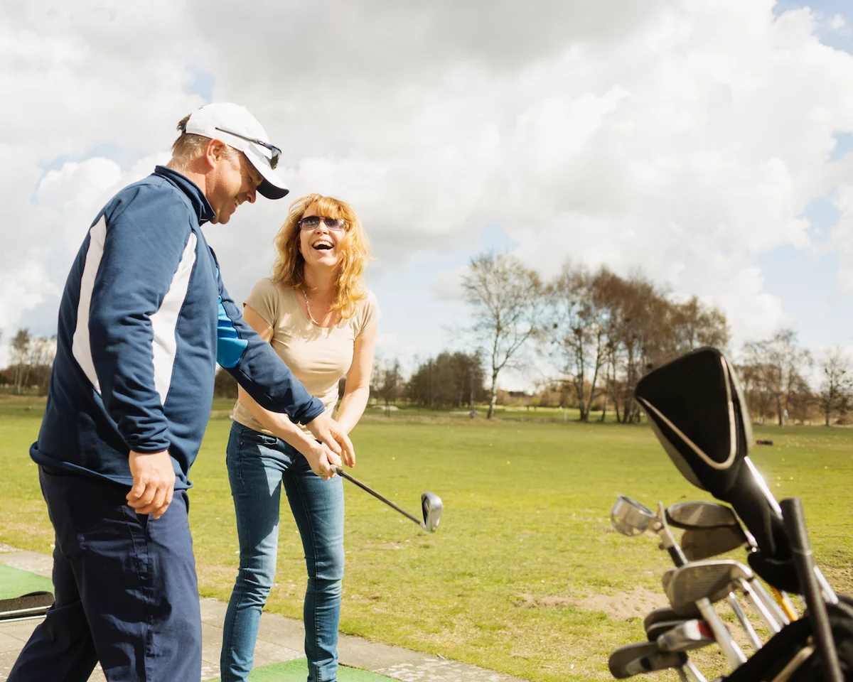 Two people having fun at driving range