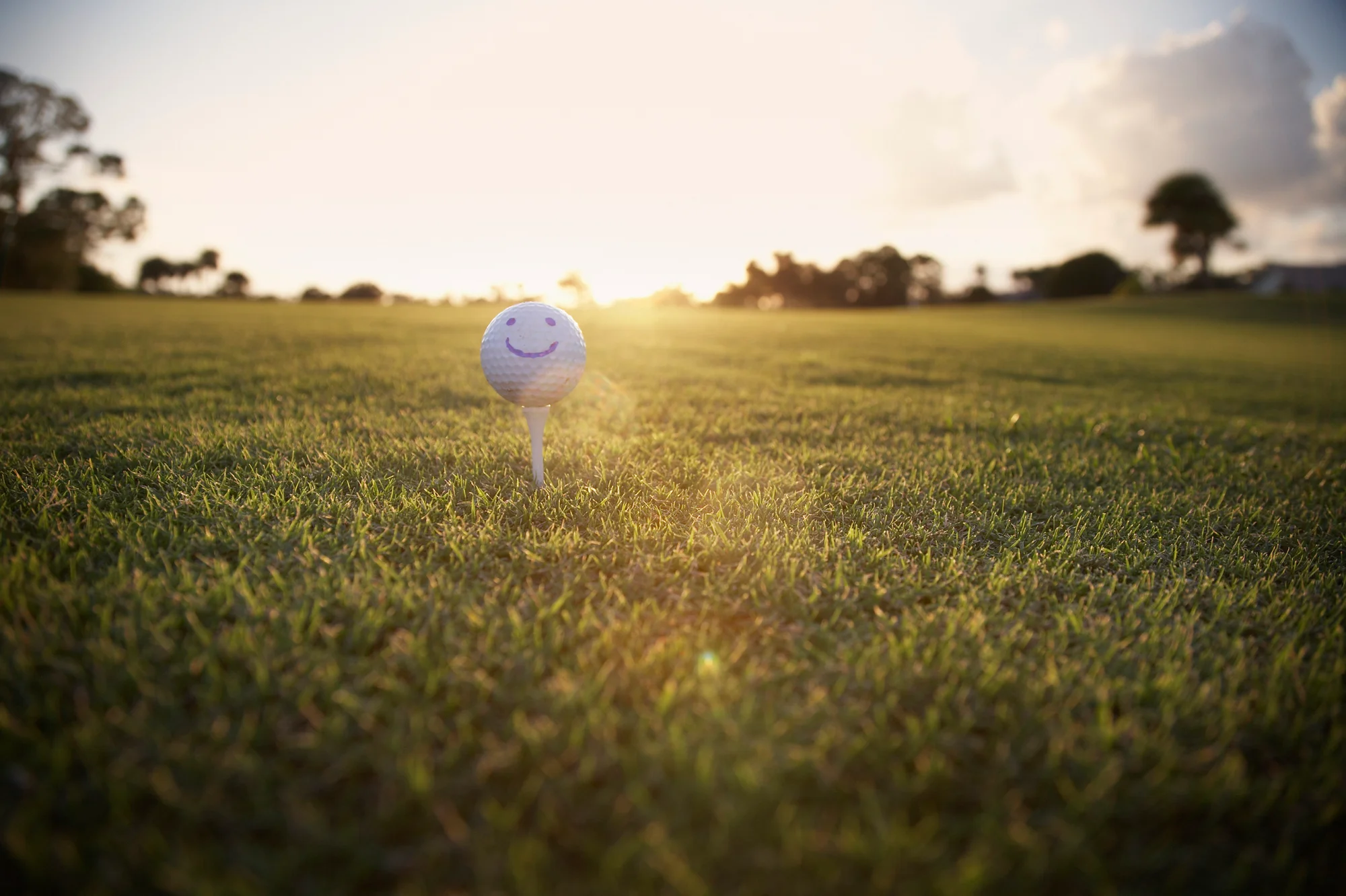 Golf ball with a smile drawn on it