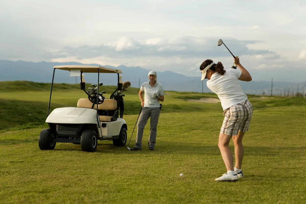 woman watching golfers swing
