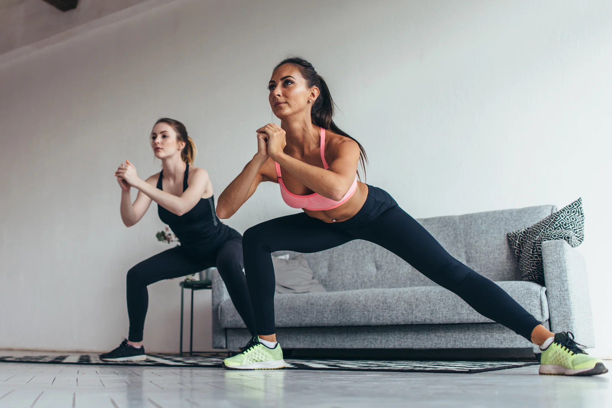 Two women performing lateral squat/lunge