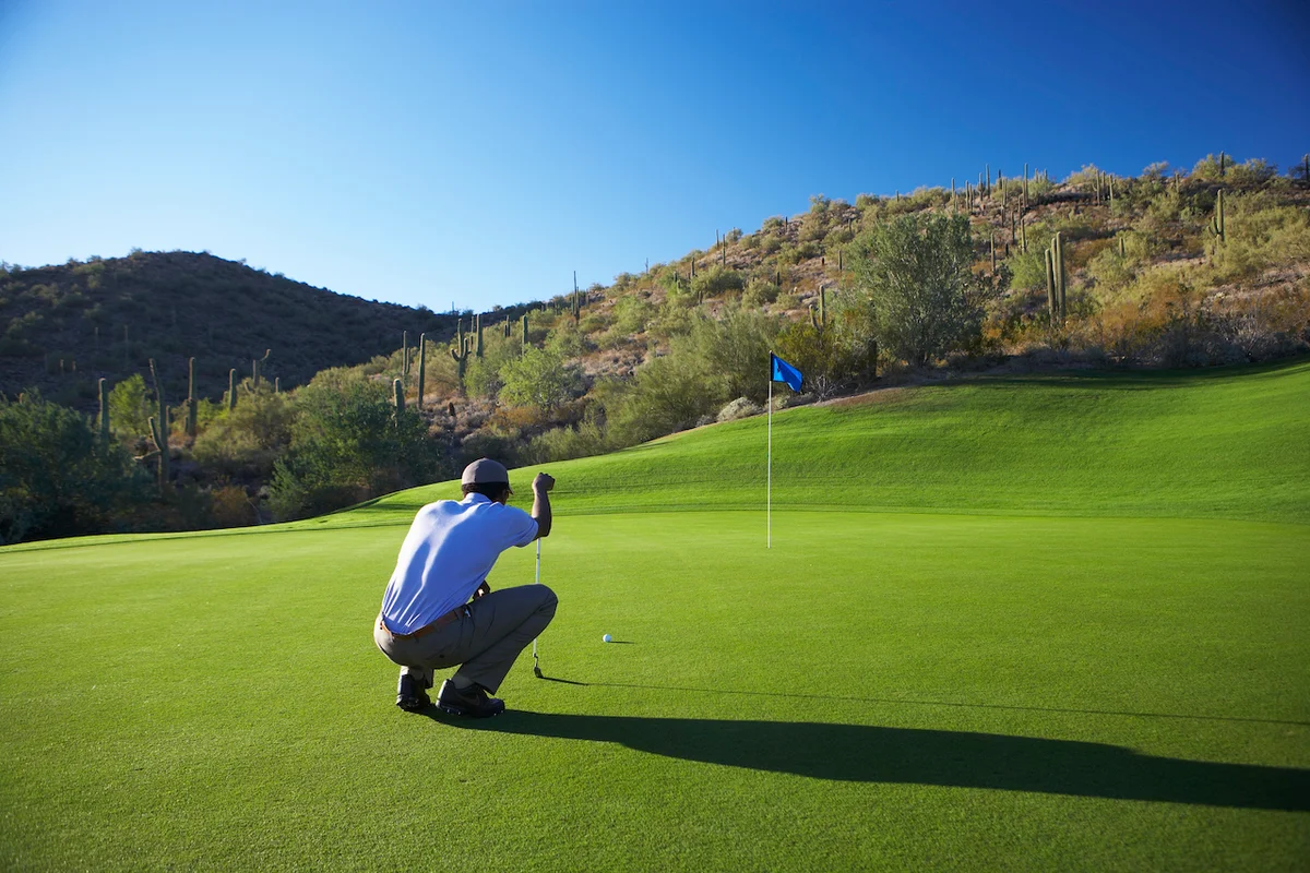 Golfer aligning putt on green