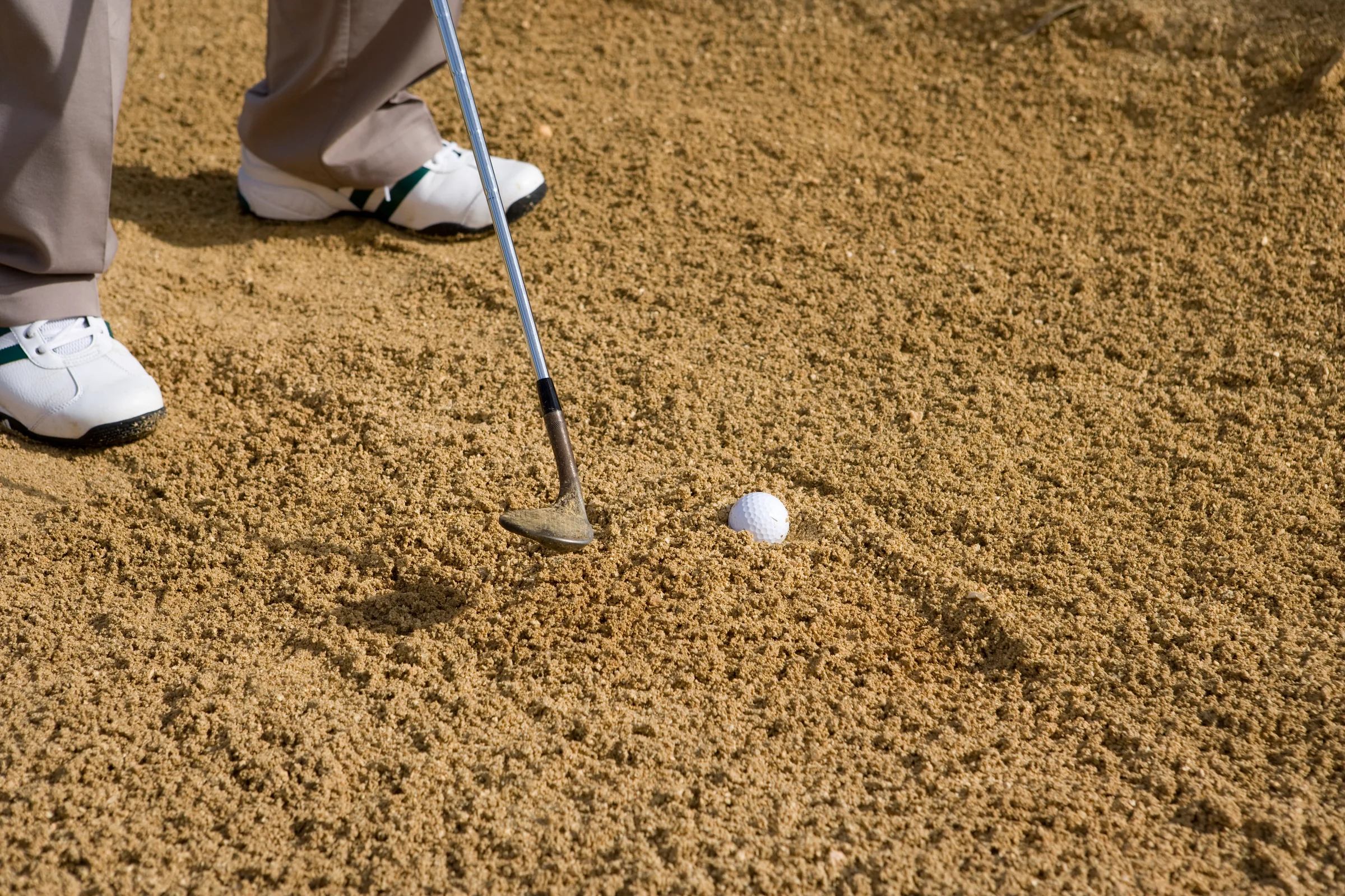 Golf ball in a fried egg lie in the bunker