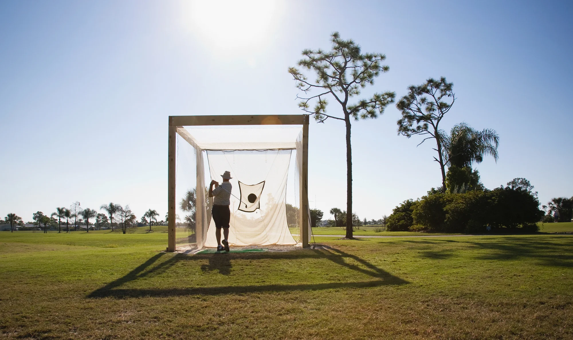 Man practicing his golf swing into a net
