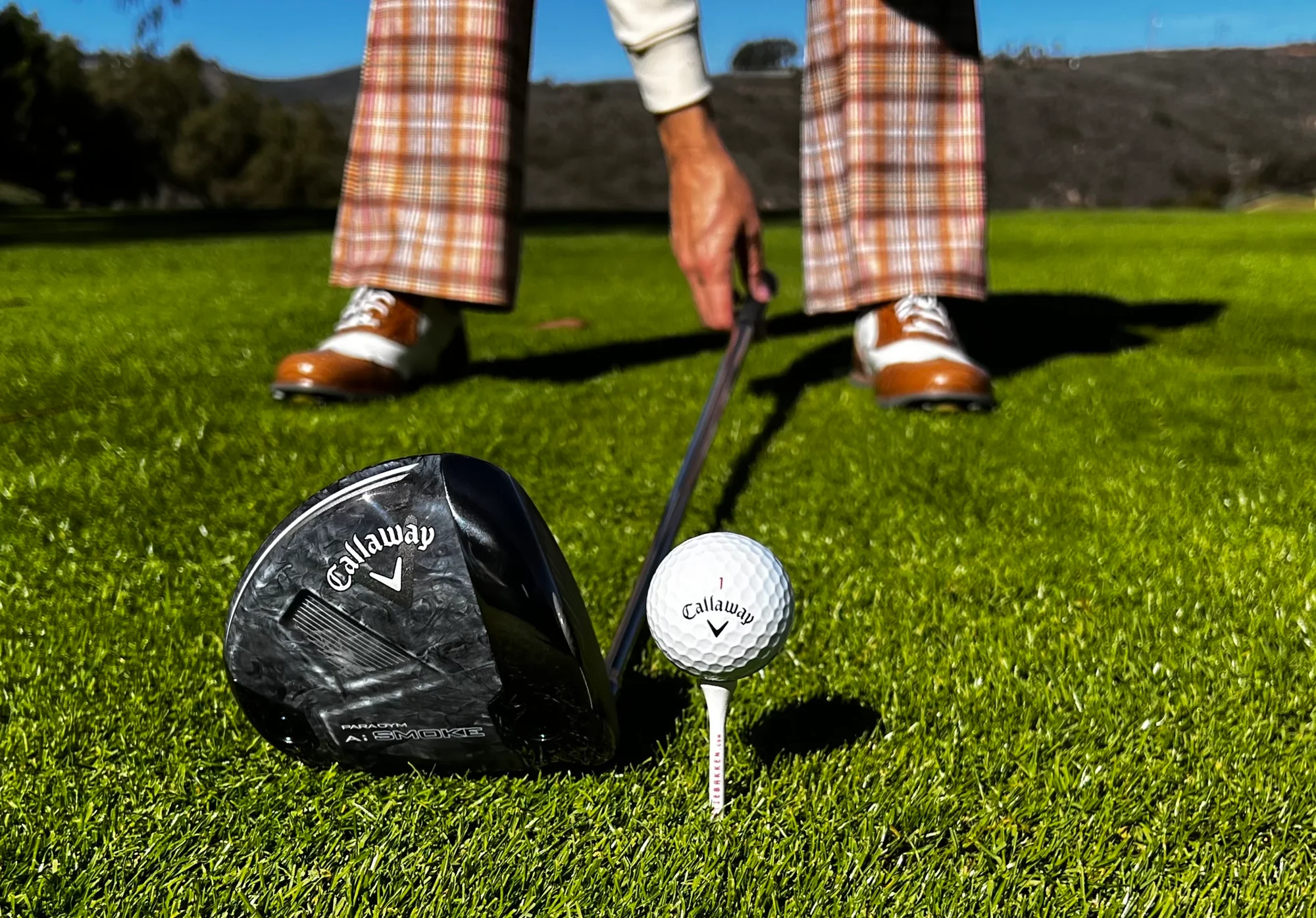 Golfer checking ball position in driver setup