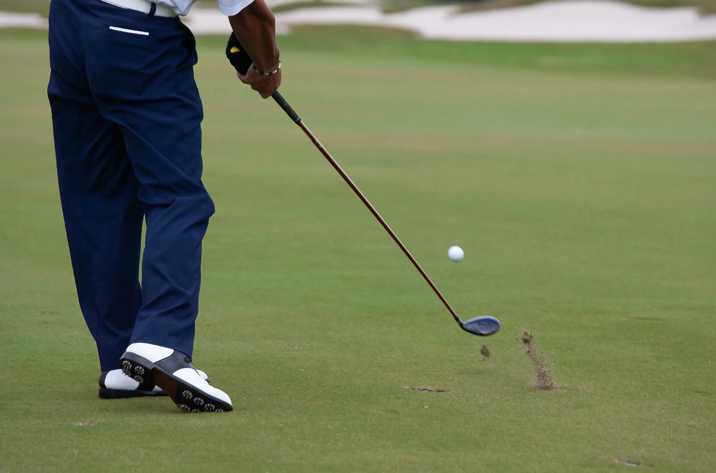 Golfer using a 7 wood from the fairway
