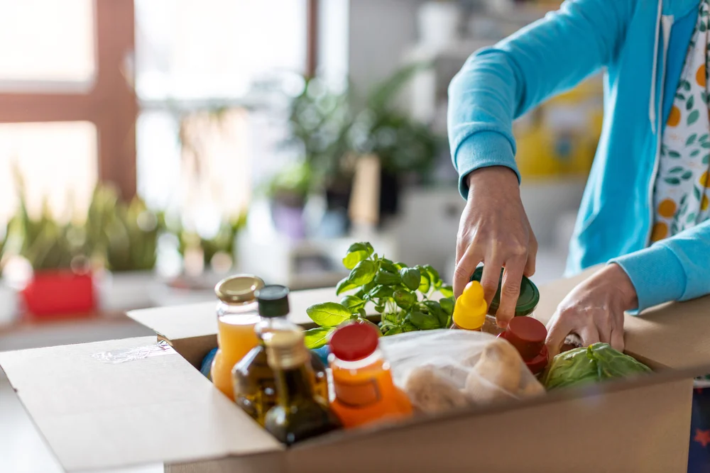 woman unpacking boxed groceries